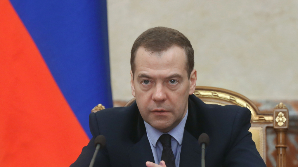 В россии вводится новый. Медведев. Медведев за столом. Медведев сидит.